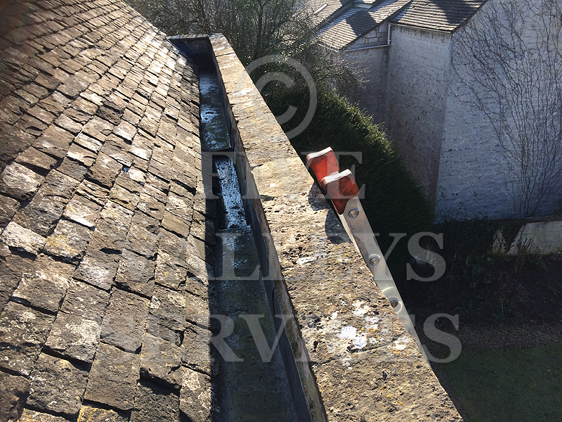 A parapet gutter between stone-slate roofs